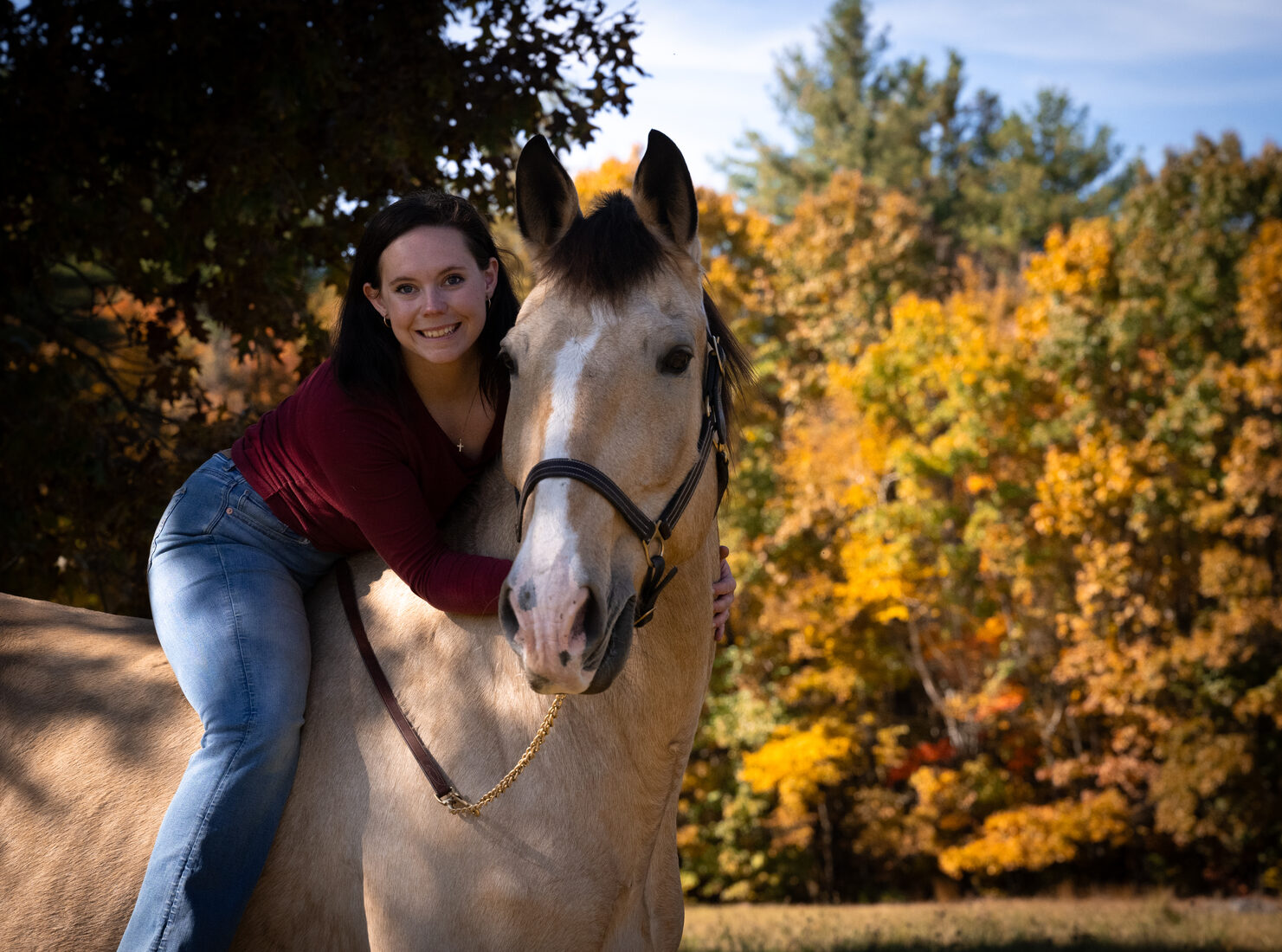 Cassie Kendall outdoors with a dog and horse
